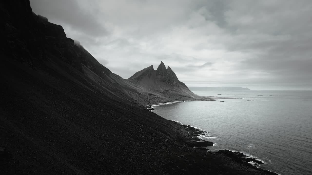 la montaña aérea épica de vesturhorn, la playa de arena negra stokksnes, el paisaje volcánico oscuro y nublado, islandia