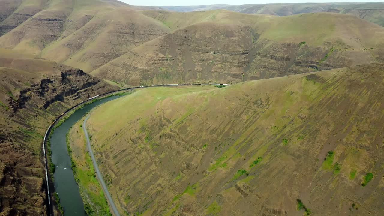 US, Oregon, Maupin, Deschutes River, 2025-05-08 - Drone view of a cargo train moving down the Deschutes River in north central Oregon in spring