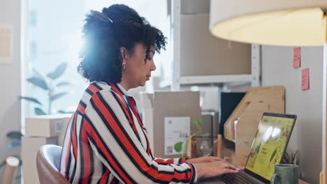 mujer, riendo y escribiendo por computadora en la oficina