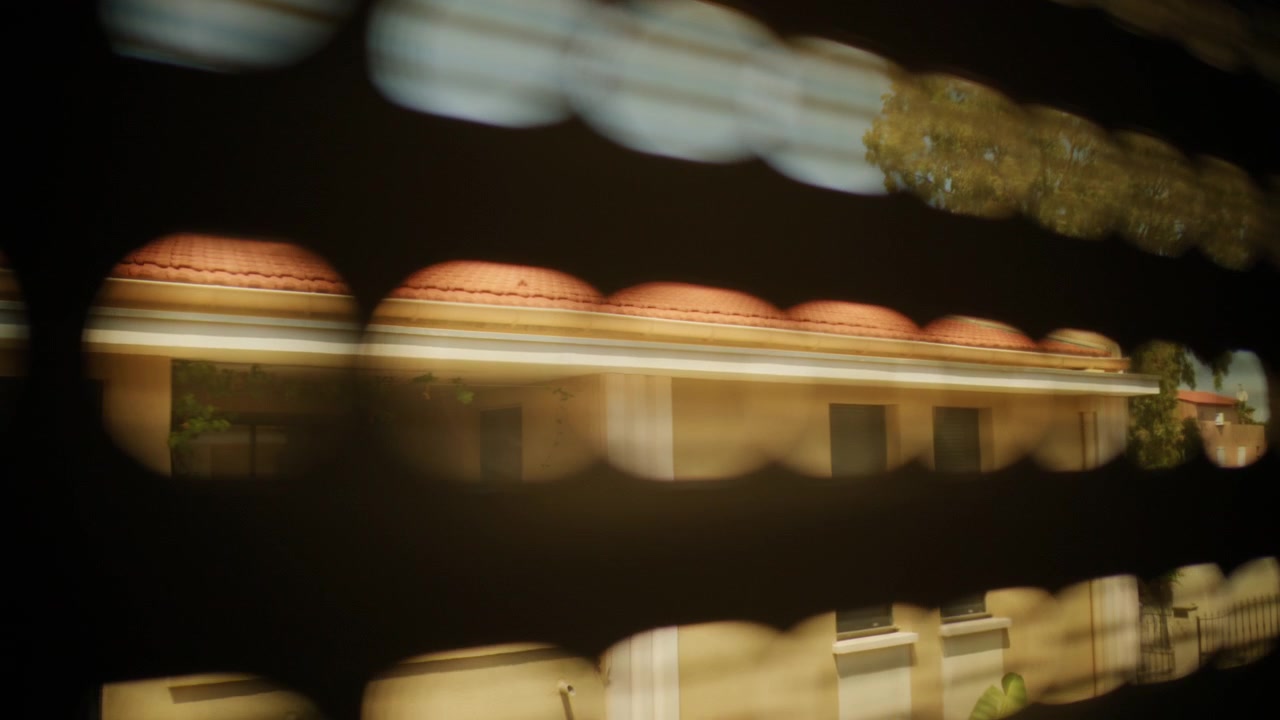 Blurred light passing through a window shutter creating an abstract pattern of glowing bokeh shapes and dark lines