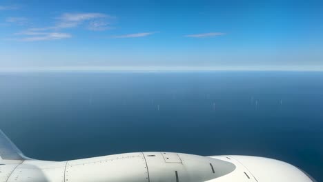 flight over the installation of wind turbines standing in the north sea. view from the airplane window.