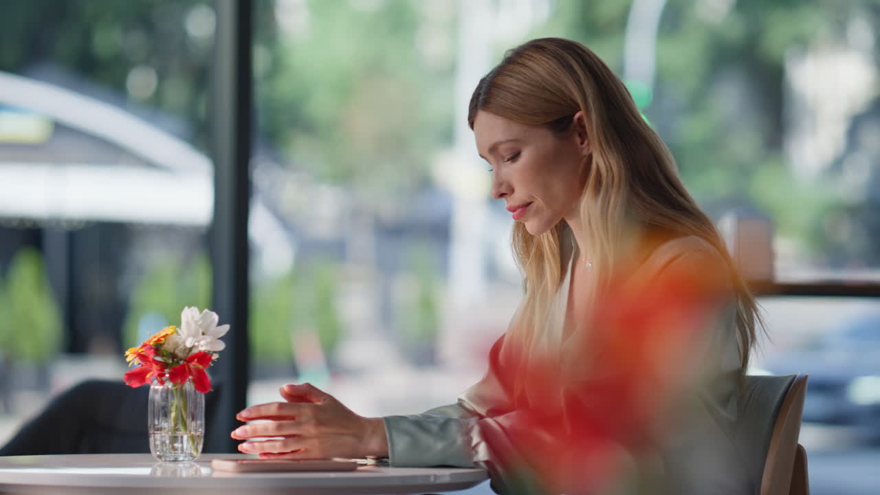 Elegant lady sitting restaurant table checking time on cellphone closeup