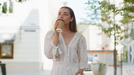 Mujer-Sonriente-Feliz-Caminando-Por-La-Calle-De-La-Ciudad-Disfrutando-De-Un-Café-Matutino,-Una-Bebida-Caliente,-Relajándose-Y-Tomando-Un-Descanso