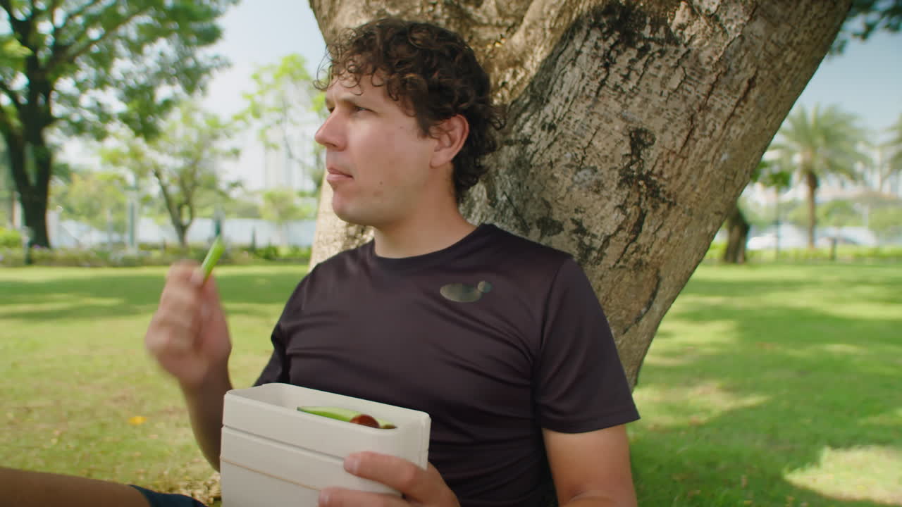 Man Eating Fresh Veggies after Training in Park