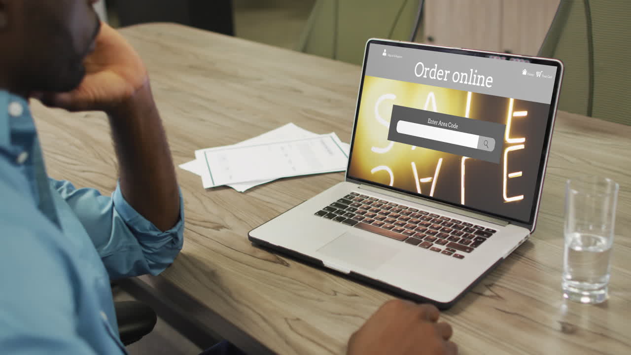 hombre afroamericano en la mesa usando portátil, compras en línea durante la venta, cámara lenta