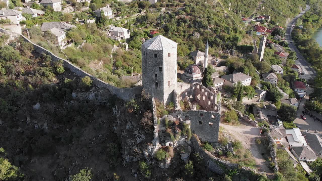 Aerial: drone flying by the tower in Počitelj fortress, in Bosnia and Hercegovina. Circular shot