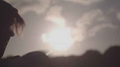 man boxing in the park, gloves silouetted against evening sun - ungraded