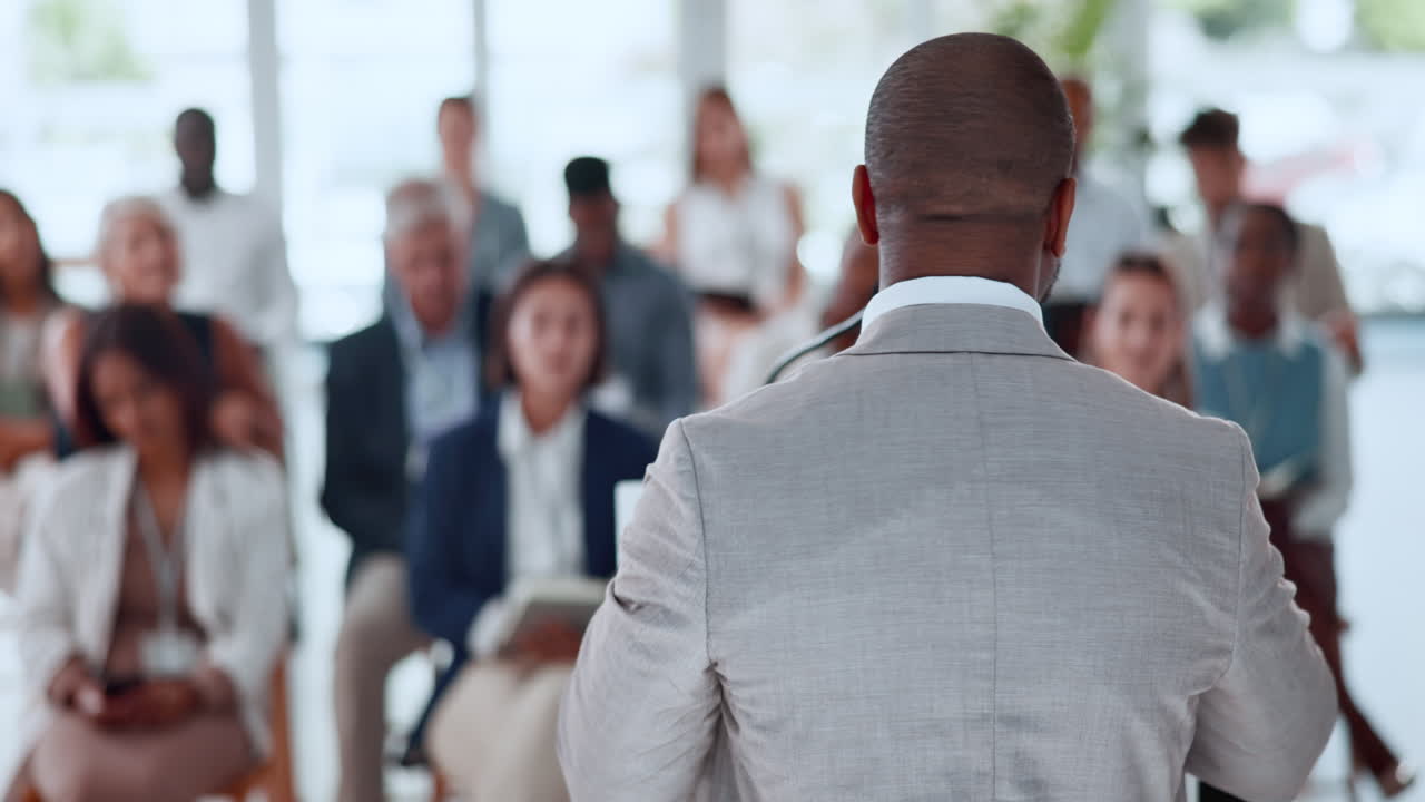 Businessman Giving Presentation to Diverse Audience at Conference