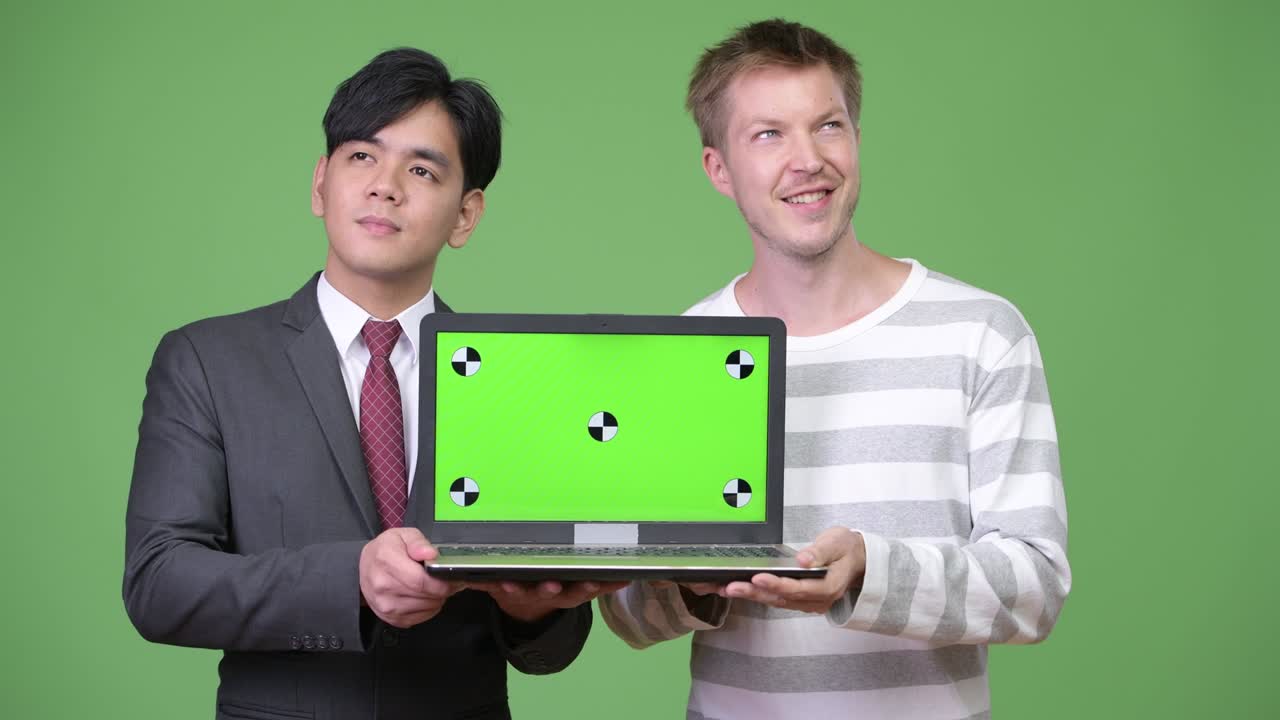 젊은 잘생긴 아시아 사업가와 젊은 스칸디나비아 사업가가 함께 일하고 있습니다.