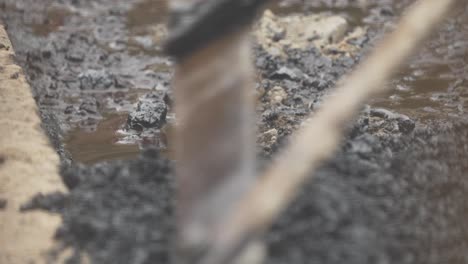 close up shot of hot gravel being raked into empty pothole