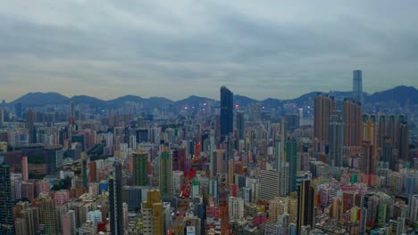 Drone-shot-,traveling-to-the-left,-of-a-big-city-during-a-cloudy-day-with-business-buildings-in-the-distance