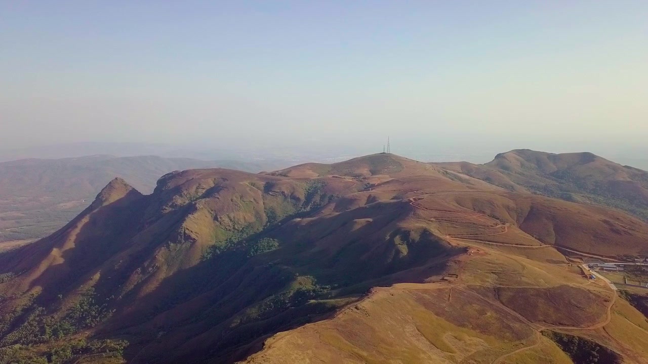 Le pittoresche colline di Chikmagalur bagnate dalla calda luce del sole e da ombre delicate, vista aerea.