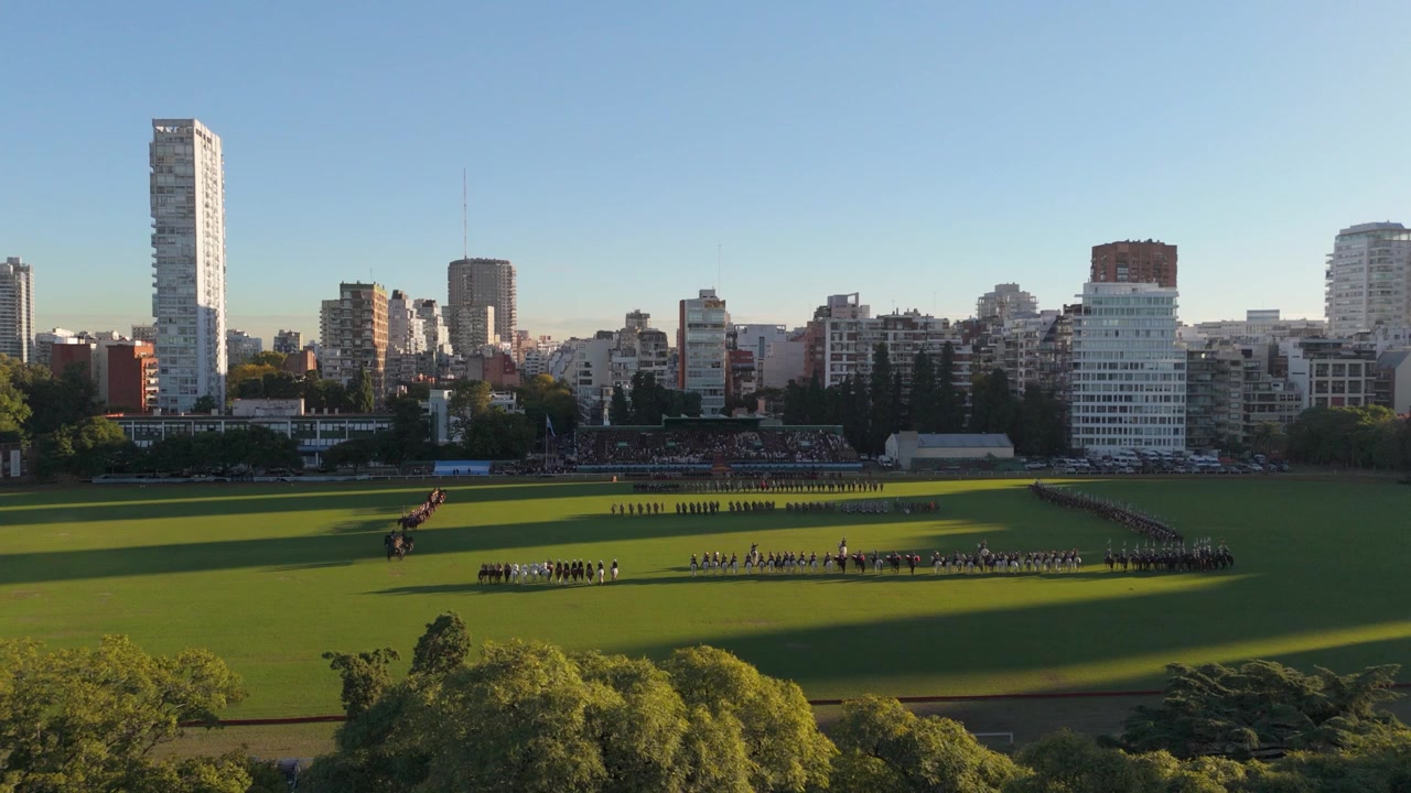 Formazione dell'esercito di cavalleria argentino sul Campo Argentino de Polo, con lo skyline della città sullo sfondo.