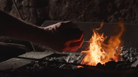 coals are added to the blacksmiths forge in the smithy. 240fps slow motion