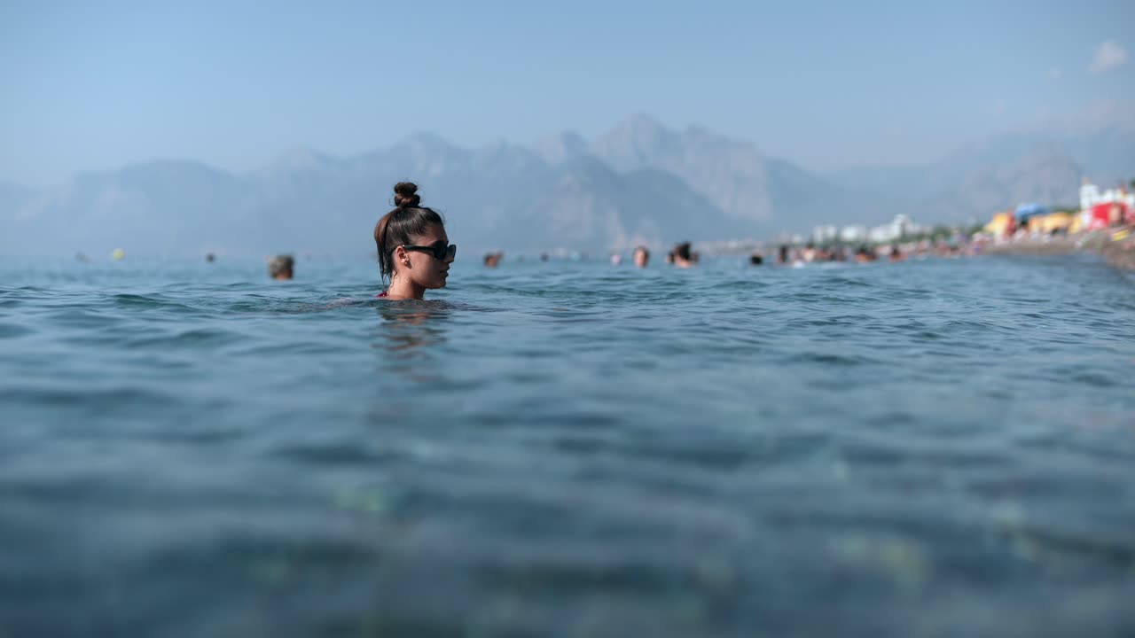 mujer nadando en el mar en un día soleado en la playa