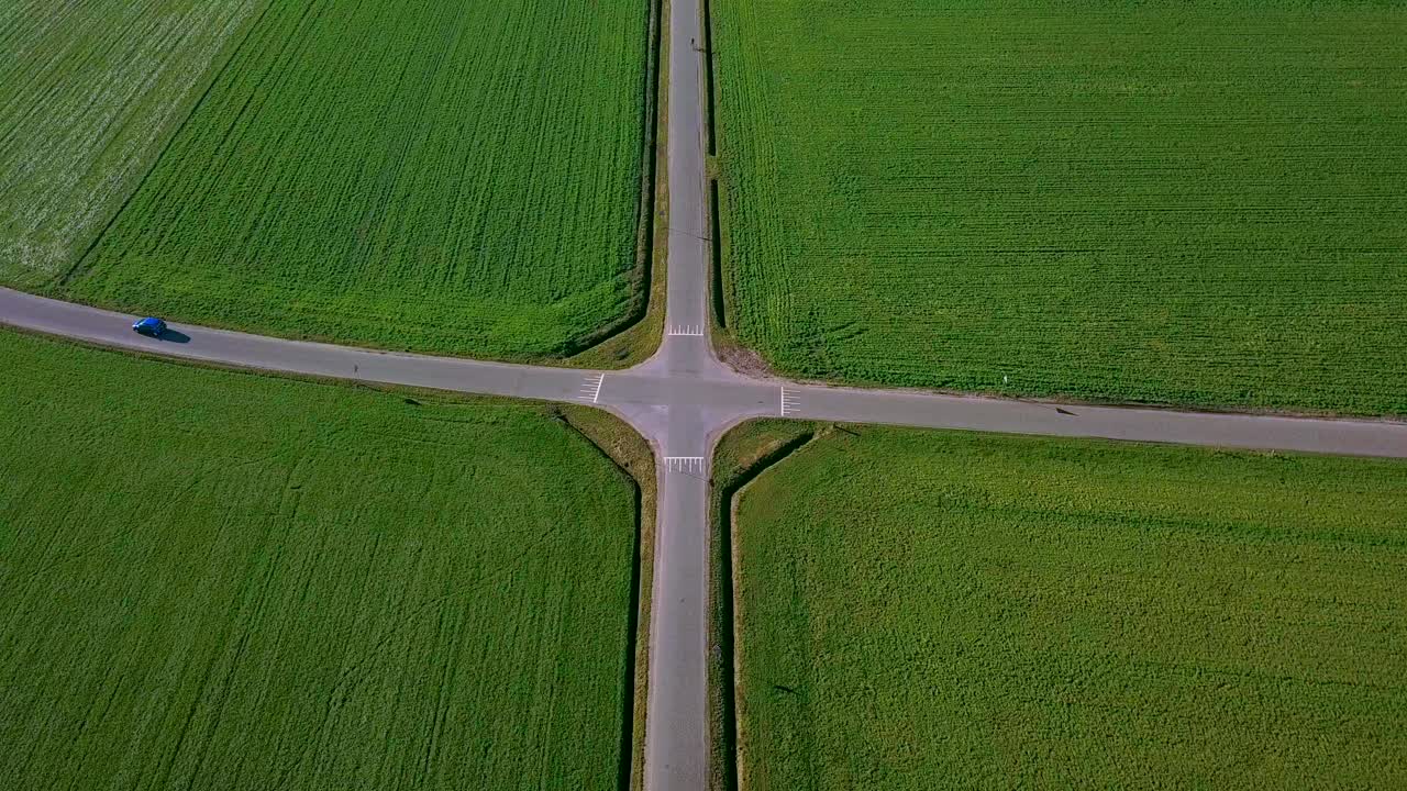 파란 차 1대가 있는 녹색 들판이 있는 완벽한 대칭 교차로의 조감도