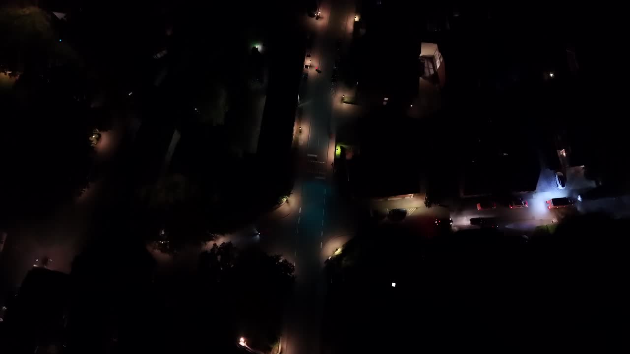 Bike crossing road at night. Aerial top down shot. Lighting lantern along road in American city. Ambulance car waiting with flashing lights. Small town of USA