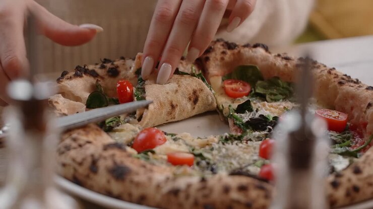 Donna che mangia una deliziosa pizza.