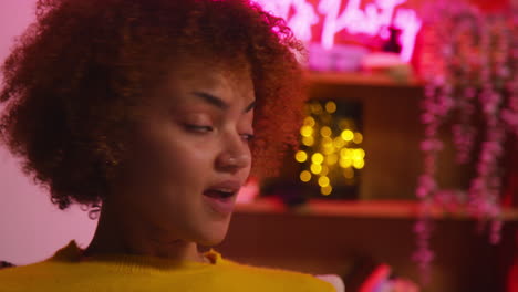 Woman with curly hair in a cozy room at night.
