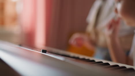 el niño toca la palanca del piano y la hermana mayor le prohíbe tocar.