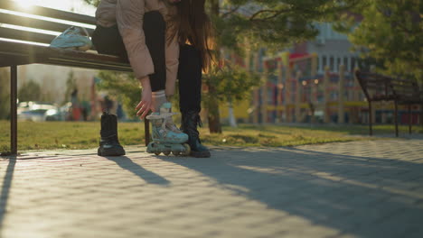 a close-up shot capturing a person in a park wearing one light blue rollerblade while the other leg is still in a black boot, preparing to switch from walking to skating