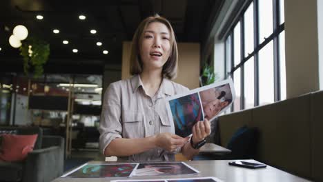 asian businesswoman having a video chat going through paperwork modern office