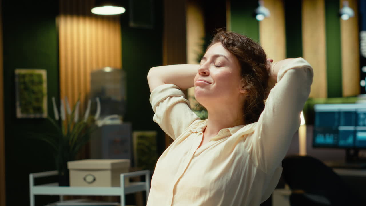 Vertical Video Businesswoman sits in a chair in a relaxed pose at midnight