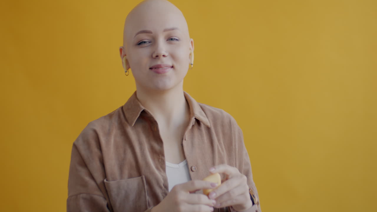 Bald woman with earplugs
