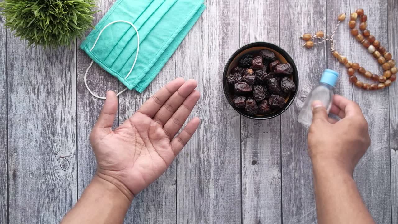 usar desinfectante para las manos para prevenir el virus y recoger frutas de dátiles de un cuenco