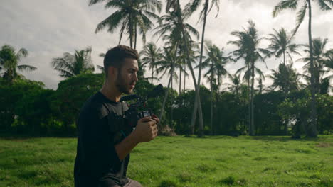 medium shot of content creator filming with big camera in tropical location