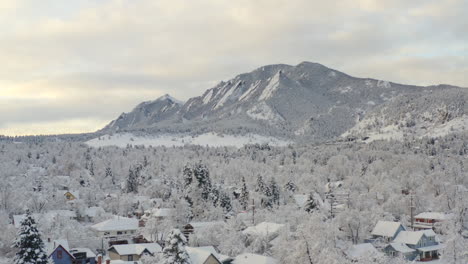 Tiro-Bajo-De-Drones-Moviéndose-A-La-Derecha-De-Boulder-Colorado-Y-Montañas-Rocosas-Flatiron-Después-De-Una-Gran-Tormenta-De-Nieve-Invernal-Cubre-árboles,-Casas,-Calles-Y-Vecindarios-En-Nieve-Blanca-Fresca-Para-Las-Vacaciones