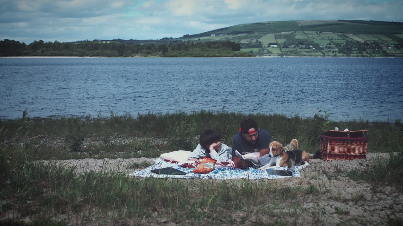 4k 아버지, 아들, 개가 피크닉을 하고 있습니다.