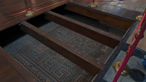 floor mosaic in the church of the nativity roped off and below wooden beams