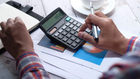 businessman using calculator and charts