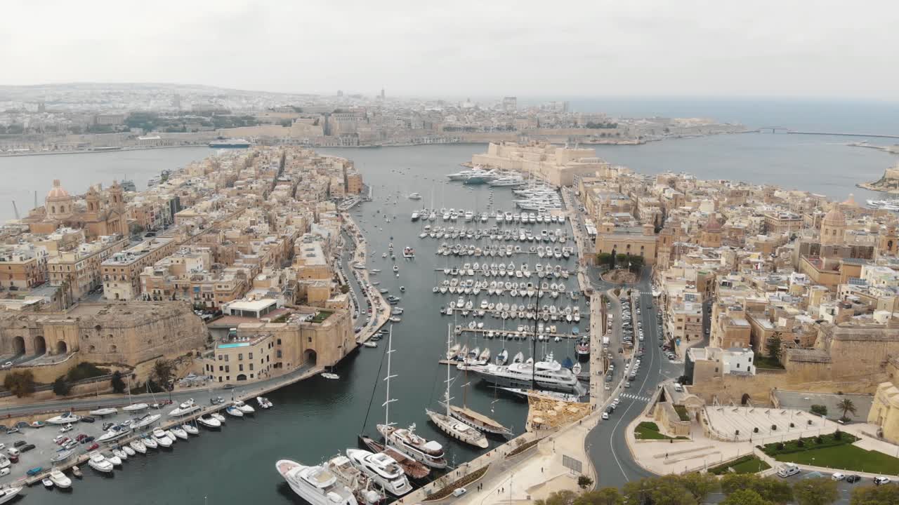 Ampia panoramica aerea in 4k con drone dei porti delle 'Tre Città di Malta' lungo la costa del Mar Mediterraneo.