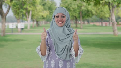 Happy-Muslim-woman-showing-thumbs-up-in-park