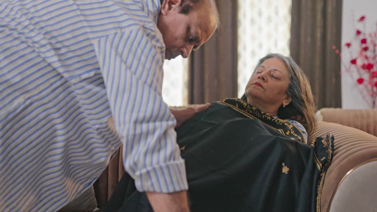 el marido indio le da una manta a su esposa mientras ella dormía.