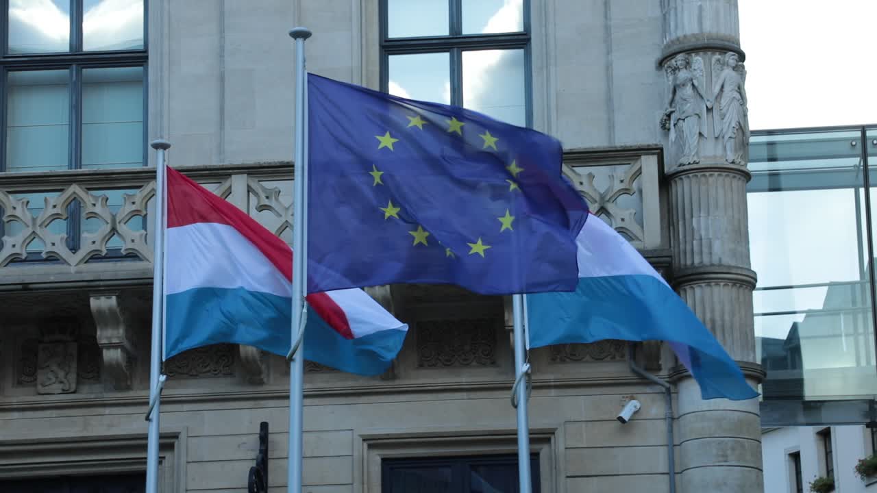 Bandiere del Lussemburgo e dell'UE che sventolano davanti a un edificio storico