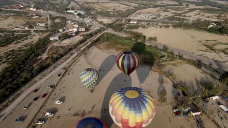 vista aérea del aterrizaje de coloridos globos de aire caliente al atardecer durante el festival de globos