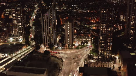 Imágenes-De-Diapositivas-Y-Panorámicas-De-Automóviles-Que-Conducen-A-Través-De-La-Intersección-De-Carreteras-En-La-Ciudad.-Vista-Aérea-De-La-Calle-Iluminada-Por-La-Noche.-Londres,-Reino-Unido