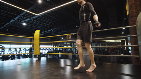 sporty fit man making jumps in sport club. male boxer exercising at gym