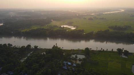 a breathtaking footage of a sunrise over a picturesque rural landscape, with farmland, a meandering river