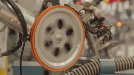 handheld shot of spinning wheel in a clothing factory assembly line