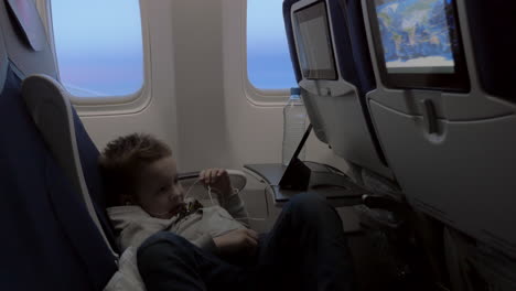 niño viendo dibujos animados en su teléfono inteligente en el avión