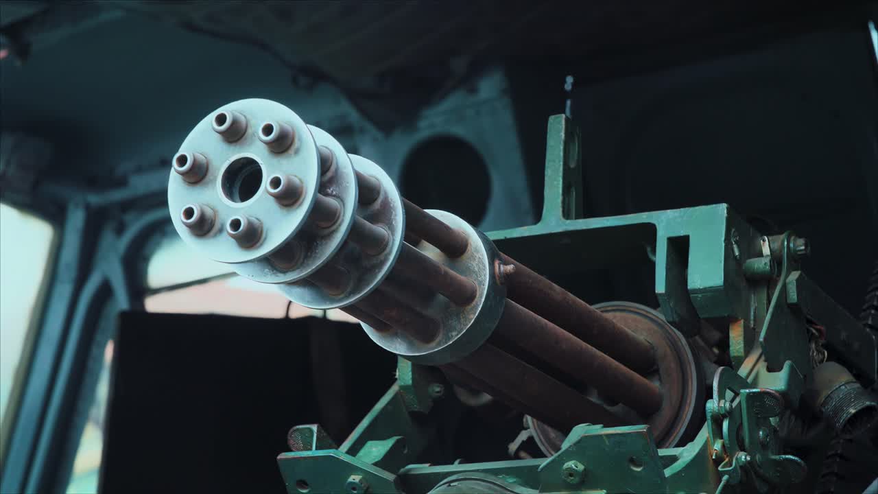 Close-up shot of a mounted Gatling-style rotary machine gun barrels inside a military vehicle or aircraft