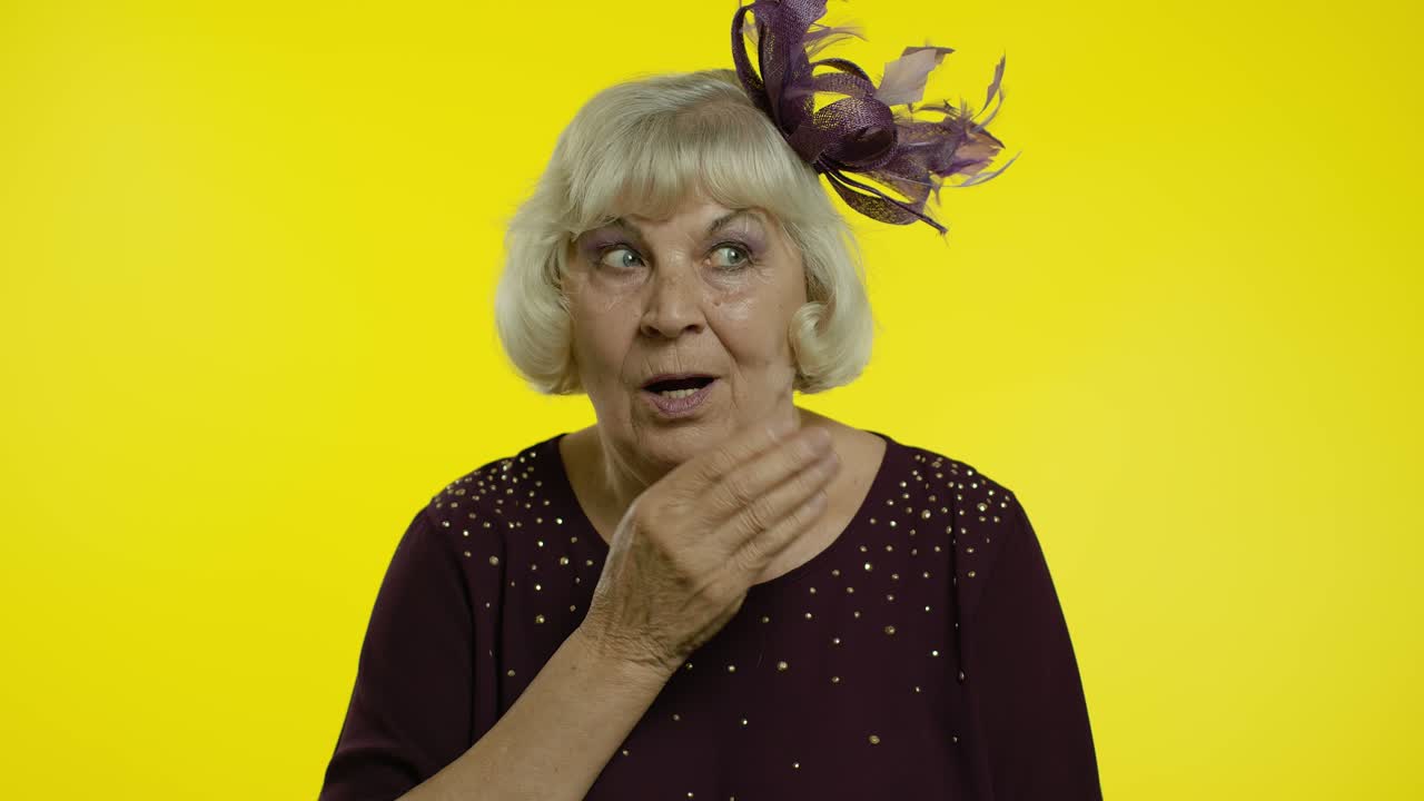 Anziana donna che apre la bocca per lo stupore, con un'espressione sorpresa e scioccata. Rallentatore.