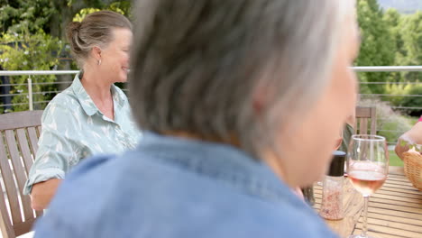 Senior-biracial-woman-enjoys-a-conversation-outdoors