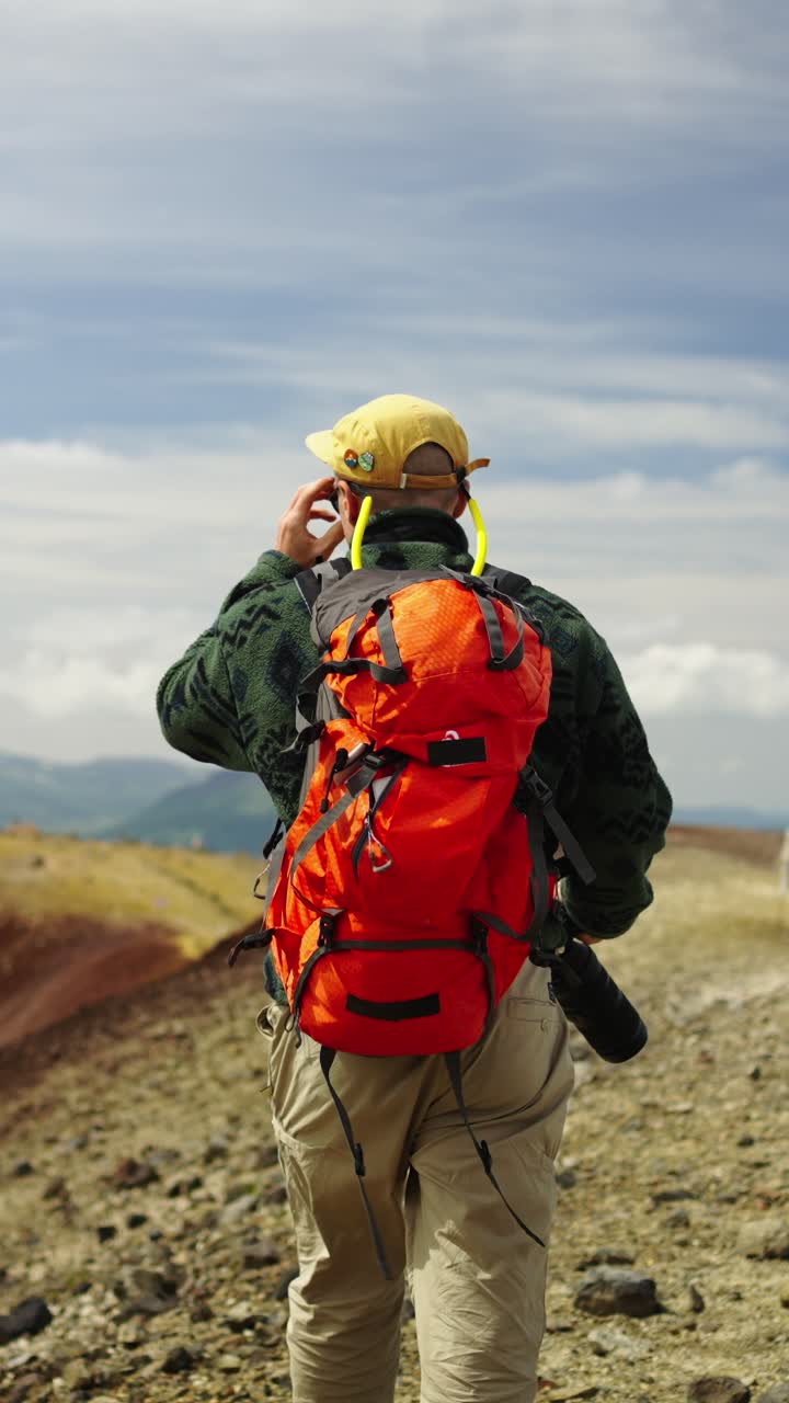 Uomo con zaino che fa trekking e parla al telefono nelle Montagne Rocciose