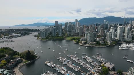 Toma-Aérea-De-Establecimiento-Del-Horizonte-De-La-Ciudad-De-Vancouver-Con-Edificios-De-Gran-Altura-Y-Estacionamiento-De-Barcos-Y-Yates-En-El-Muelle-De-Falls-Creek,-Canadá---Vuelo-Descendente