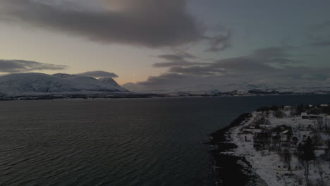 vivid polar night - snow covered mountains with windy conditions